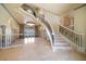 Bright living room with tile floors, columns, grand staircase, and access to an outdoor area with water views at 26 Sunset Bay Drive, Belleair, FL 33756