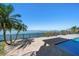 Beautiful backyard pool area with a water view and palm trees at 26 Sunset Bay Drive, Belleair, FL 33756