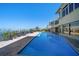 Large backyard pool with a water view and palm trees at 26 Sunset Bay Drive, Belleair, FL 33756