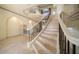 Elegant staircase with a decorative iron railing, tile steps, and detailed architectural design at 26 Sunset Bay Drive, Belleair, FL 33756