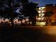 Evening view of condo building with lit balconies and surrounding trees at 2700 Bayshore Blvd # 11302, Dunedin, FL 34698