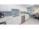 Modern kitchen with white cabinets, stainless steel appliances, and mosaic backsplash at 2700 Bayshore Blvd # 11302, Dunedin, FL 34698