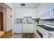 Galley kitchen with white cabinets, stainless steel sink and appliances at 2700 Bayshore Blvd # 4309, Dunedin, FL 34698