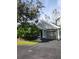Well-maintained exterior featuring a one car garage and mature trees at 3653 Kings Rd # 101, Palm Harbor, FL 34685