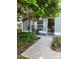 Inviting front entry with lush landscaping and a charming bench at 3653 Kings Rd # 101, Palm Harbor, FL 34685