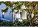 Inviting front porch with seating, partially visible home entrance, and lush landscaping at 3653 Kings Rd # 101, Palm Harbor, FL 34685