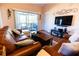 Spacious living room with leather sofas and a large TV at 3653 Kings Rd # 101, Palm Harbor, FL 34685