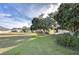 View of a spacious backyard with lush green grass and mature trees at 37347 Derbyshire Dr, Zephyrhills, FL 33542