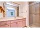 Bathroom with pink vanity, large mirror and shower at 37347 Derbyshire Dr, Zephyrhills, FL 33542