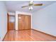 Bedroom with hardwood floors, ceiling fan and double doors closet at 37347 Derbyshire Dr, Zephyrhills, FL 33542