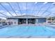 Community pool with screened enclosure and lounge chairs at 37347 Derbyshire Dr, Zephyrhills, FL 33542