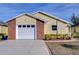 Eye-catching yellow house with a white garage door and brick accents at 37347 Derbyshire Dr, Zephyrhills, FL 33542
