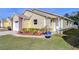 Attractive yellow house showcasing a side view and lush landscaping at 37347 Derbyshire Dr, Zephyrhills, FL 33542