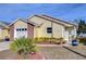 Front view of a charming yellow house with well-maintained landscaping at 37347 Derbyshire Dr, Zephyrhills, FL 33542