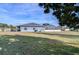 Home exterior showcasing a large backyard, a screened enclosure, and a partly sunny day at 37347 Derbyshire Dr, Zephyrhills, FL 33542