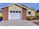 Brick and yellow exterior with a white garage door at 37347 Derbyshire Dr, Zephyrhills, FL 33542