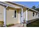 White front door entry with small porch and potted plants at 37347 Derbyshire Dr, Zephyrhills, FL 33542
