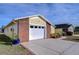 White garage door with brick facade and landscaping at 37347 Derbyshire Dr, Zephyrhills, FL 33542