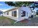 Rear view of a single-story house with a well-maintained lawn and landscaping at 37347 Derbyshire Dr, Zephyrhills, FL 33542