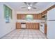 Bright kitchen with wood cabinets, white appliances and tile floor at 37347 Derbyshire Dr, Zephyrhills, FL 33542