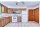Bright kitchen with white appliances and wood cabinets at 37347 Derbyshire Dr, Zephyrhills, FL 33542