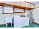Laundry room with washer, dryer, shelving, and utility sink at 37347 Derbyshire Dr, Zephyrhills, FL 33542