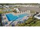 L-shaped community pool with surrounding patio and lounge chairs at 4062 Cadence Loop, Land O Lakes, FL 34638