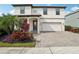Two-story house with a white facade, paver driveway, and landscaping at 4062 Cadence Loop, Land O Lakes, FL 34638