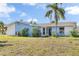 Blue and white ranch home with palm trees and well-maintained lawn at 5708 Bayshore Dr, Seminole, FL 33772
