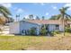 Ranch style home with blue exterior, white accents, and a landscaped yard at 5708 Bayshore Dr, Seminole, FL 33772