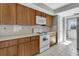 View of kitchen with wood cabinets and white appliances at 5708 Bayshore Dr, Seminole, FL 33772