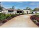 Home's exterior showcasing landscaping and a long driveway at 6226 Hampton N Ct, St Petersburg, FL 33710