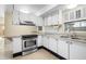 White kitchen with stainless steel appliances and granite countertops at 713 Gran Kaymen Way, Apollo Beach, FL 33572