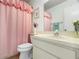 Simple bathroom with pink shower curtain at 7713 Hillside Ct # 201, Hudson, FL 34667