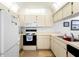 Bright eat-in kitchen with white cabinets and appliances at 7713 Hillside Ct # 201, Hudson, FL 34667