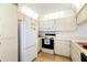 Galley kitchen with white cabinets and appliances at 7713 Hillside Ct # 201, Hudson, FL 34667