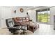 Living room with brown leather furniture and access to backyard at 8321 Wildflower Glen Ave, Odessa, FL 33556