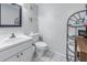 Clean bathroom with white vanity, toilet, and storage shelving at 8954 Antigua Dr, Seminole, FL 33777