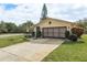 Front view of a house with a large driveway and manicured lawn at 102 Stafford Dr, Palm Harbor, FL 34684