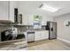 Bright kitchen featuring white cabinets and gray tile backsplash at 1224 Palm St, Clearwater, FL 33755