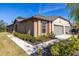 Tan house with gray two-car garage and landscaping at 13987 Weddington Ter, Hudson, FL 34669