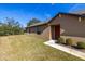 Tan house exterior with red door and landscaping at 13987 Weddington Ter, Hudson, FL 34669