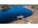 Aerial view of a peaceful lake with a wooden dock, perfect for relaxing or fishing at 13987 Weddington Ter, Hudson, FL 34669