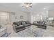 Living room with gray sofas, glass coffee table, and ceiling fan at 13987 Weddington Ter, Hudson, FL 34669