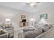 Living room with gray sofas, glass coffee table, and ceiling fan at 13987 Weddington Ter, Hudson, FL 34669