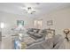 Living room with gray sofas, glass coffee table, and ceiling fan at 13987 Weddington Ter, Hudson, FL 34669