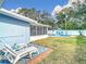 Spacious backyard with lounge chairs and a view of the pool at 1447 Santa Anna Dr, Dunedin, FL 34698