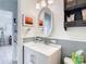 Bathroom with vanity, oval mirror, and gray-blue wainscoting at 1447 Santa Anna Dr, Dunedin, FL 34698