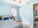 Light blue bedroom with a double bed, light wood floors, and window blinds at 1447 Santa Anna Dr, Dunedin, FL 34698