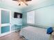 Bedroom with twin bed, TV, and light blue walls at 1447 Santa Anna Dr, Dunedin, FL 34698